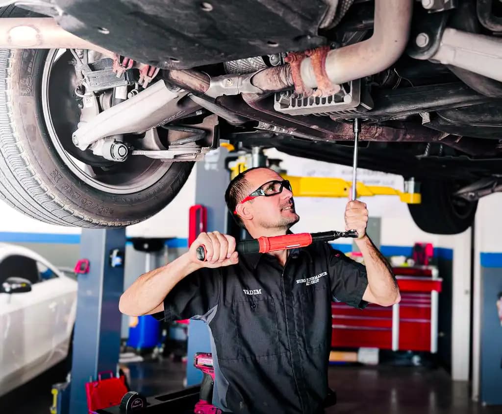 Euro Performance technician tightening a bolt under a car on the lift